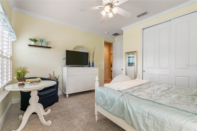 carpeted bedroom with ornamental molding, a closet, and ceiling fan