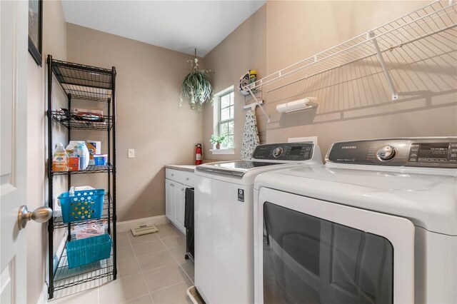 clothes washing area with separate washer and dryer, cabinets, and light tile patterned floors