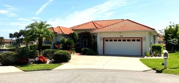 mediterranean / spanish home with concrete driveway, a tiled roof, an attached garage, and stucco siding