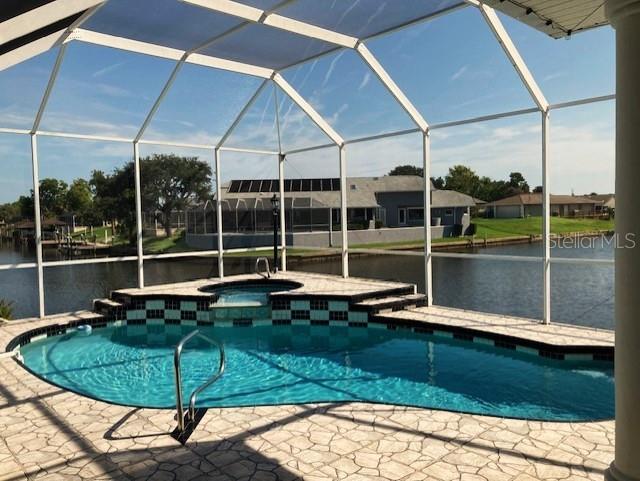 view of pool featuring a patio, an in ground hot tub, and a lanai