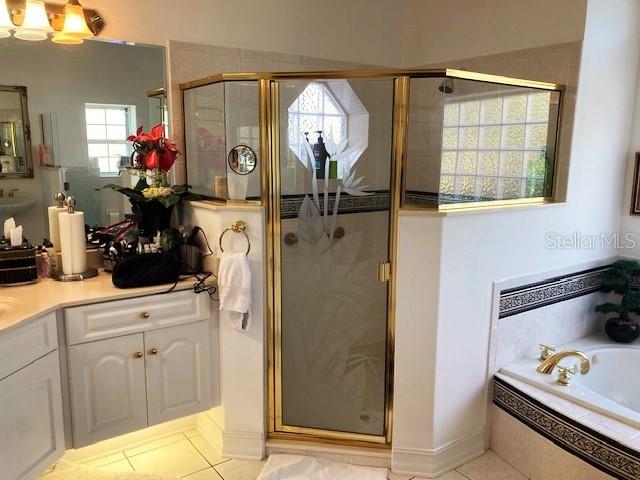 bathroom featuring shower with separate bathtub, tile patterned floors, and vanity