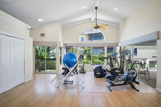 workout area featuring high vaulted ceiling, ceiling fan, and light wood-type flooring