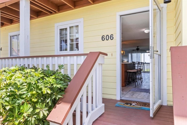 view of exterior entry with a porch and ceiling fan