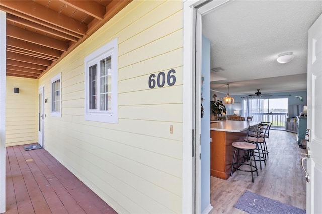 wooden deck featuring a bar and ceiling fan