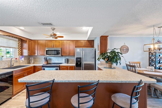 kitchen with backsplash, ceiling fan with notable chandelier, light hardwood / wood-style floors, appliances with stainless steel finishes, and sink