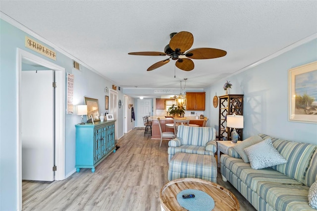 living room featuring light hardwood / wood-style flooring, crown molding, and ceiling fan