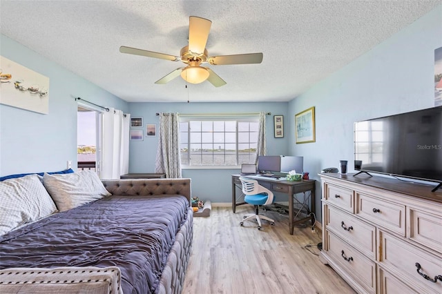 bedroom featuring light hardwood / wood-style floors, a textured ceiling, and ceiling fan