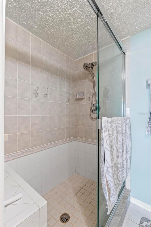 bathroom featuring tile patterned floors, a textured ceiling, and an enclosed shower