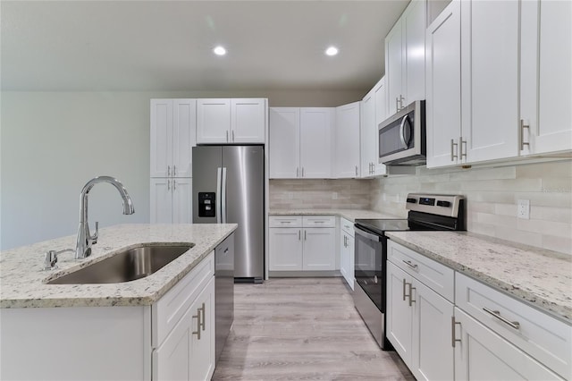 kitchen featuring sink, light hardwood / wood-style flooring, white cabinets, and stainless steel appliances