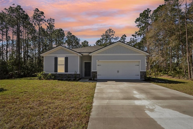 view of front of property featuring a yard and a garage