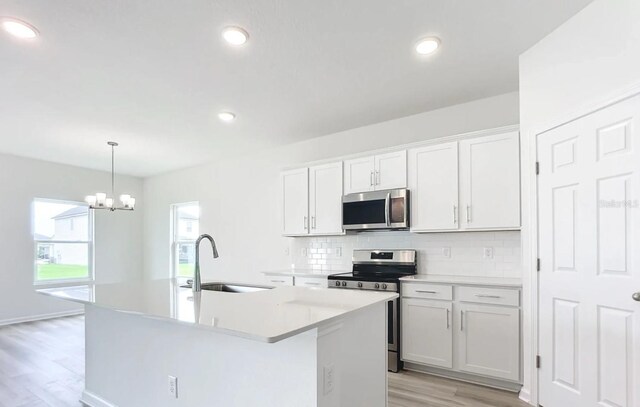 kitchen featuring appliances with stainless steel finishes, light countertops, white cabinetry, and a sink