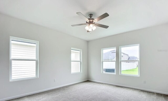 unfurnished room featuring light colored carpet, ceiling fan, and baseboards