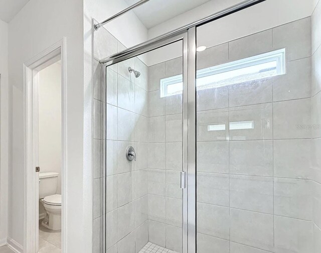 bathroom with a stall shower and toilet