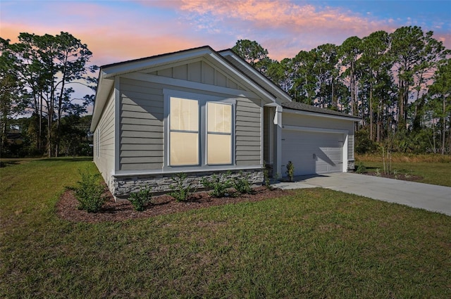 property exterior at dusk featuring a garage and a lawn