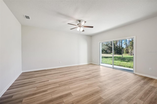 spare room featuring ceiling fan, light hardwood / wood-style flooring, and a textured ceiling