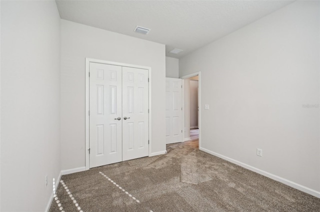 unfurnished bedroom featuring carpet and a closet