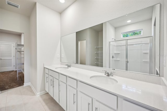 bathroom with vanity, a shower with door, and tile patterned flooring