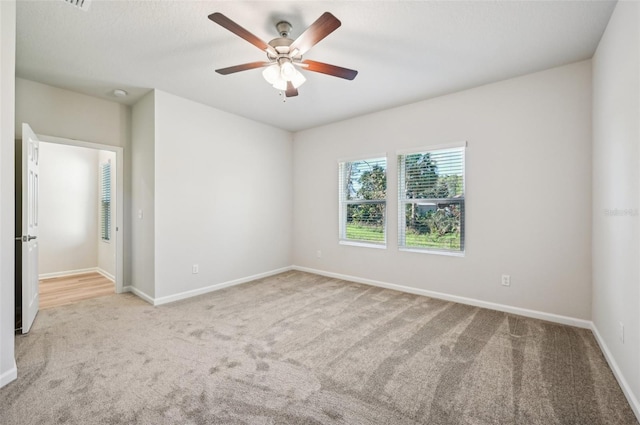 spare room featuring ceiling fan and light carpet