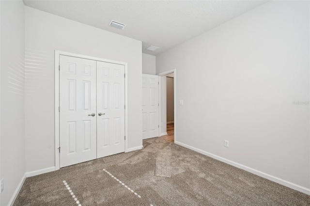 unfurnished bedroom featuring a closet and carpet flooring