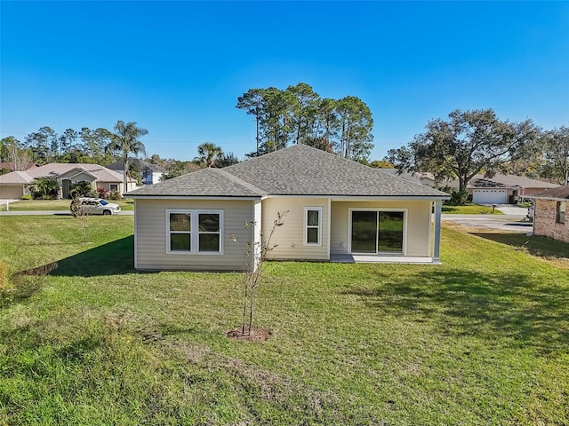 rear view of property featuring a lawn