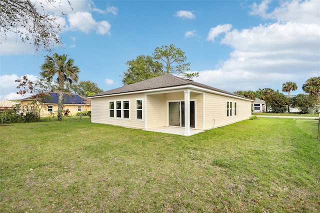 rear view of property featuring a yard and a patio area