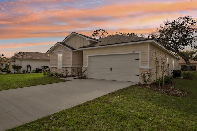 view of front facade with central AC, a garage, and a yard