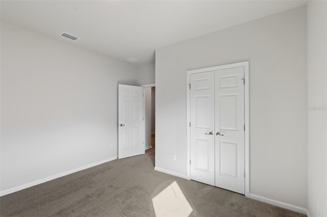 unfurnished bedroom featuring a closet and carpet flooring