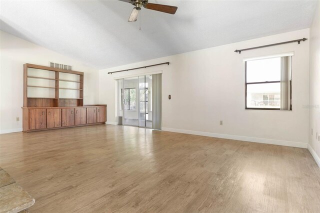 unfurnished living room featuring ceiling fan, wood-type flooring, and vaulted ceiling