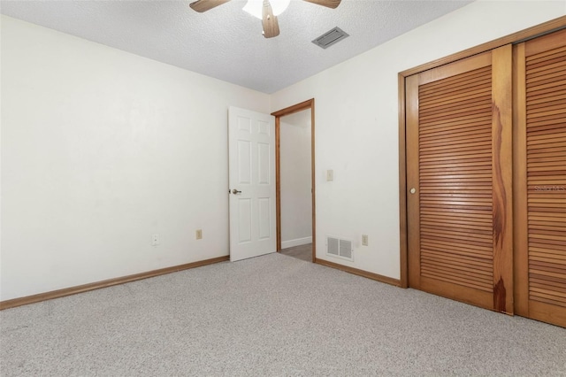 unfurnished bedroom with a closet, carpet flooring, a textured ceiling, and ceiling fan