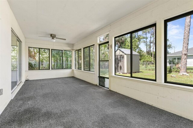 unfurnished sunroom with ceiling fan