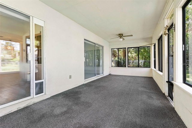 unfurnished sunroom featuring a healthy amount of sunlight and ceiling fan