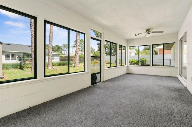 unfurnished sunroom with ceiling fan and plenty of natural light