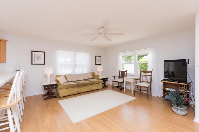 living room with light hardwood / wood-style flooring and ceiling fan