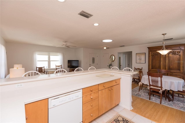 kitchen featuring light wood-type flooring, a textured ceiling, white dishwasher, ceiling fan, and decorative light fixtures