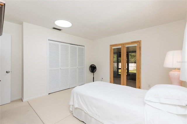 bedroom with a closet, light colored carpet, french doors, and access to exterior