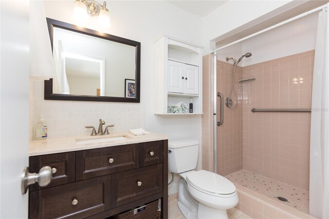 bathroom with tiled shower, backsplash, toilet, and vanity