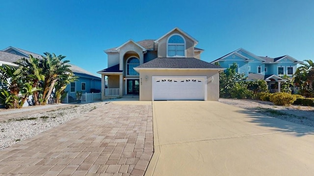 view of front facade featuring stucco siding, driveway, and a garage