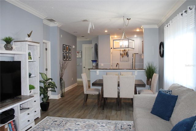 dining room with wood-type flooring, crown molding, and an inviting chandelier