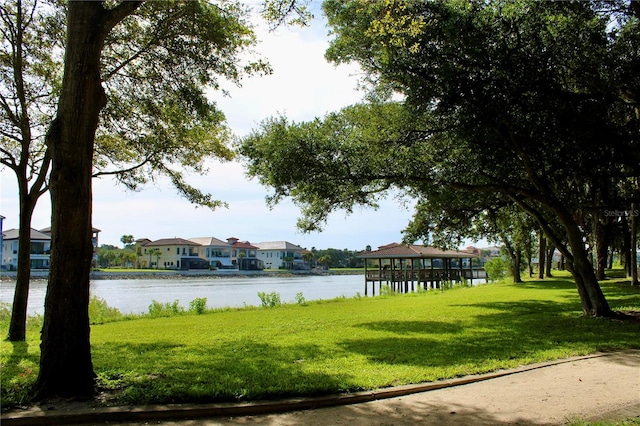 view of property's community with a water view and a yard