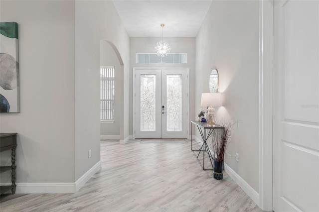 foyer entrance with light hardwood / wood-style flooring and a chandelier