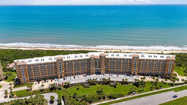 bird's eye view featuring a water view and a beach view