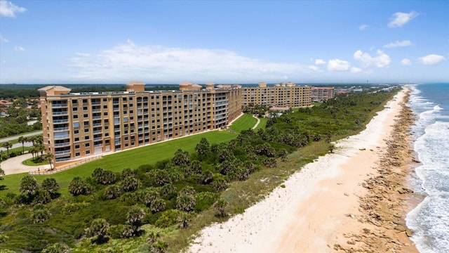 birds eye view of property with a water view and a beach view