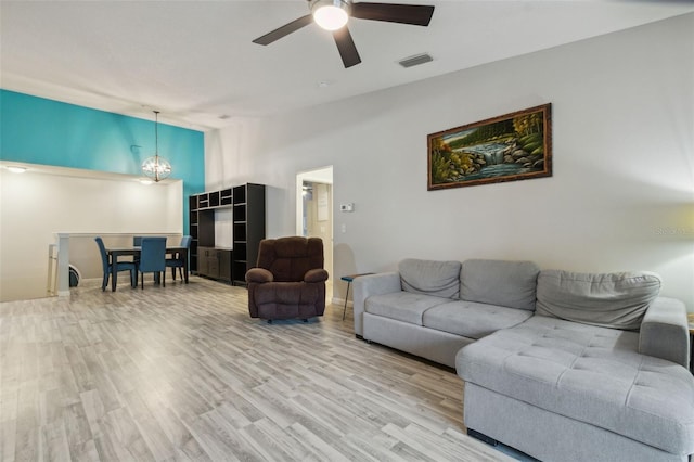 living room with light wood-style floors, visible vents, vaulted ceiling, and ceiling fan with notable chandelier