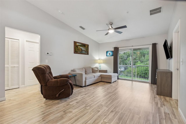 living area featuring lofted ceiling, light wood-style flooring, visible vents, and a ceiling fan