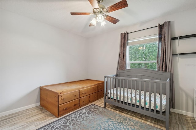 bedroom with light wood-style flooring, baseboards, and ceiling fan