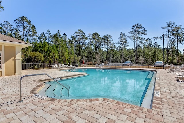 community pool with fence and a patio