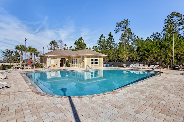 pool with fence and a patio