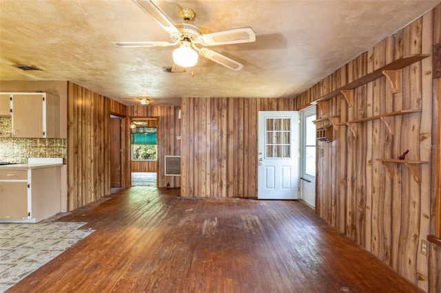 interior space with wooden walls, ceiling fan, and hardwood / wood-style floors