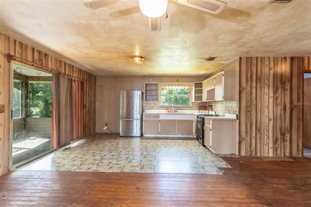 kitchen featuring stove, light hardwood / wood-style flooring, stainless steel refrigerator, and ceiling fan