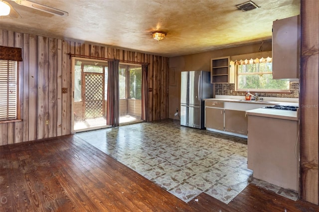 kitchen with sink, light wood-type flooring, ceiling fan, and stainless steel fridge